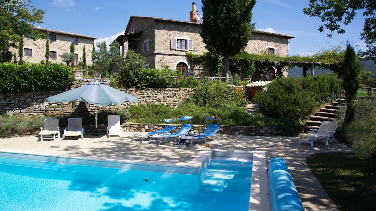 The infinity pool with farmhouse originating from the 12th Century and converted barn in the background 